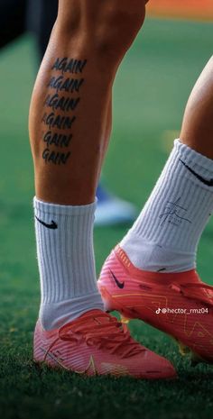 the legs and ankles of a person with tattoos on their feet, wearing pink nike shoes