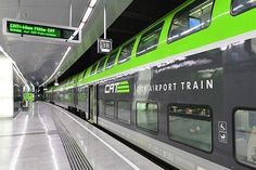 a green and black train is at the station