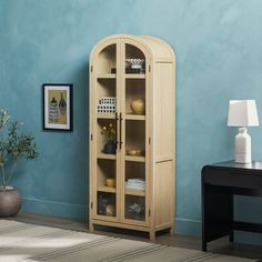 a room with blue walls and a wooden cabinet in the corner next to a black table