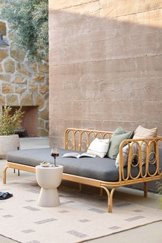 a couch sitting on top of a rug next to a stone wall