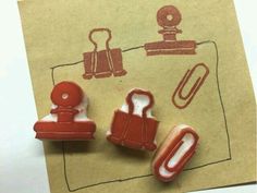 some type of magnets on top of a piece of brown paper with red ink