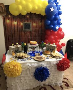 a table topped with cake and balloons