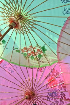 three colorful umbrellas with writing on them