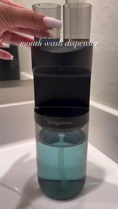 a woman's hand is touching the top of a water dispenser