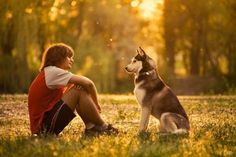 a boy and his dog are sitting in the grass