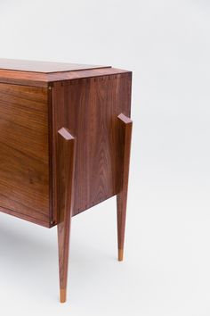 the sideboard is made out of wood and has two doors on one side, with an open drawer at the top