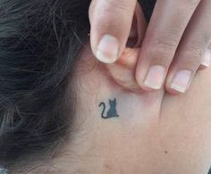 a woman with a small cat tattoo on her left side behind her ear and the back of her neck