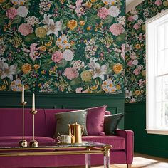 a living room with floral wallpaper and purple couch