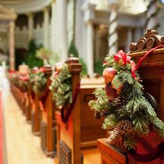 a row of wooden pews with christmas decorations on the top and bottom, along with pine cones