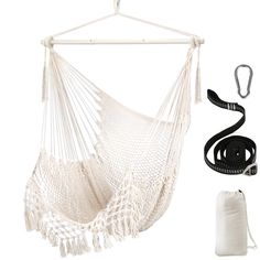 a white hammock hanging from a wooden frame with black straps and a bag