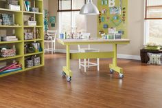 a child's playroom with green bookcases and wooden floors