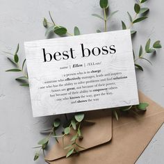 a card with the words best boss on it next to some leaves and envelopes