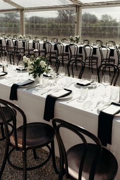 the tables are set up with black and white place settings for an elegant wedding reception