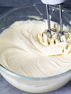 a mixer mixing cream in a glass bowl