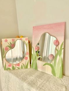 two decorative mirrors sitting on top of a table