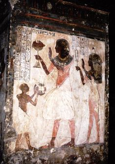 an ancient painting on the side of a building with people standing around and holding items in their hands