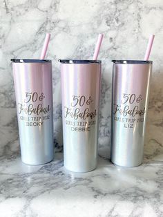 three pink tumblers sitting on top of a marble counter