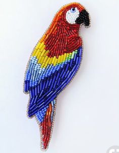 a beaded parrot sitting on top of a white surface