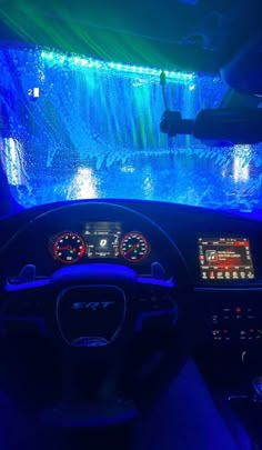 the interior of a car with blue lights and dashboard controls in front of an aquarium