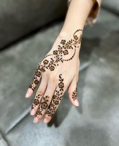 a woman's hand with henna tattoos on it