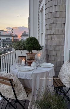 the table is set on the porch for two people to enjoy their evening meal together