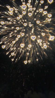 fireworks are lit up in the night sky with hearts on each side and heart - shaped lights