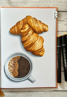 a drawing of coffee and croissants on a notebook