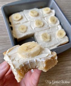 a person is holding up a piece of cake with bananas on top and frosting