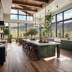 a large open kitchen with wooden floors and green cabinetry, along with an island in the center