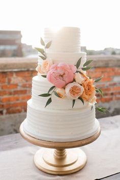 a white wedding cake with flowers on top