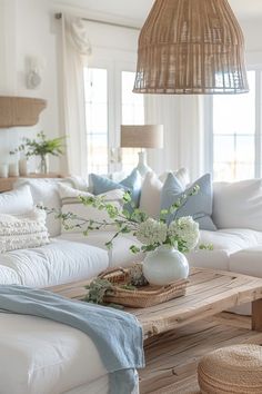 a living room filled with white furniture and pillows