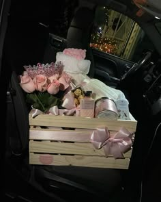 a wooden box filled with baby items in the back seat of a car at night