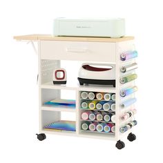 an ironing board with many different types of craft supplies on it and a printer