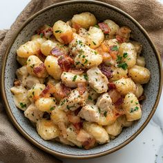 a bowl filled with macaroni and bacon on top of a white tablecloth