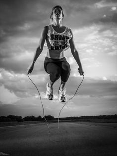 a woman jumping in the air with a jump rope