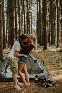 two people hugging in front of a tent