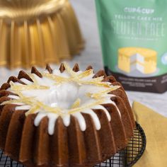 a bundt cake sitting on top of a cooling rack next to a bag of yellow cupcakes