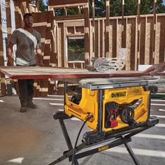 a man standing next to a table sawing