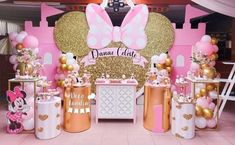 a pink and gold minnie mouse themed birthday party with balloons, decorations, and desserts