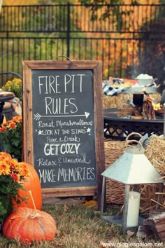 a sign that says fire pit rules next to some pumpkins and hay bales