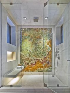 the inside of a bathroom with glass walls and an artistic painting on the shower wall