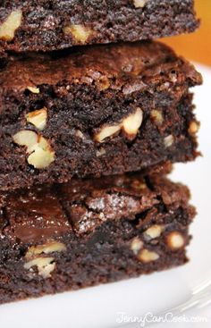 three brownies stacked on top of each other with nuts in the middle and one cut in half