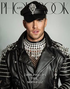 a man in a leather jacket and hat on the cover of a magazine, wearing jewelry