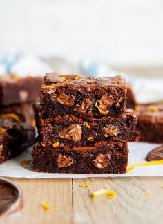 three brownies stacked on top of each other with chocolate chips and orange zest