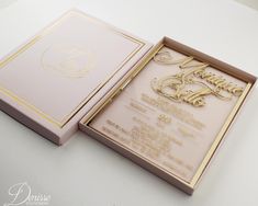 a wedding card in a pink box with gold lettering on the front and back side