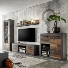 a living room with an entertainment center and bookshelves on the wall next to it