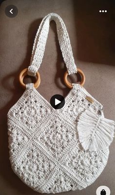 a white crocheted purse with wooden handles