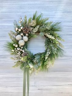 a christmas wreath with pine cones and greenery