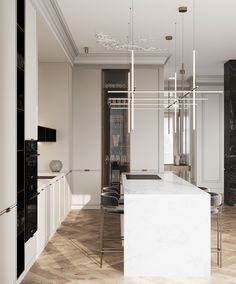 an elegant kitchen with marble counter tops and white cabinets, along with modern lighting fixtures