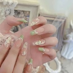 a woman's hand with green and white nail polishes on her nails in front of a mirror